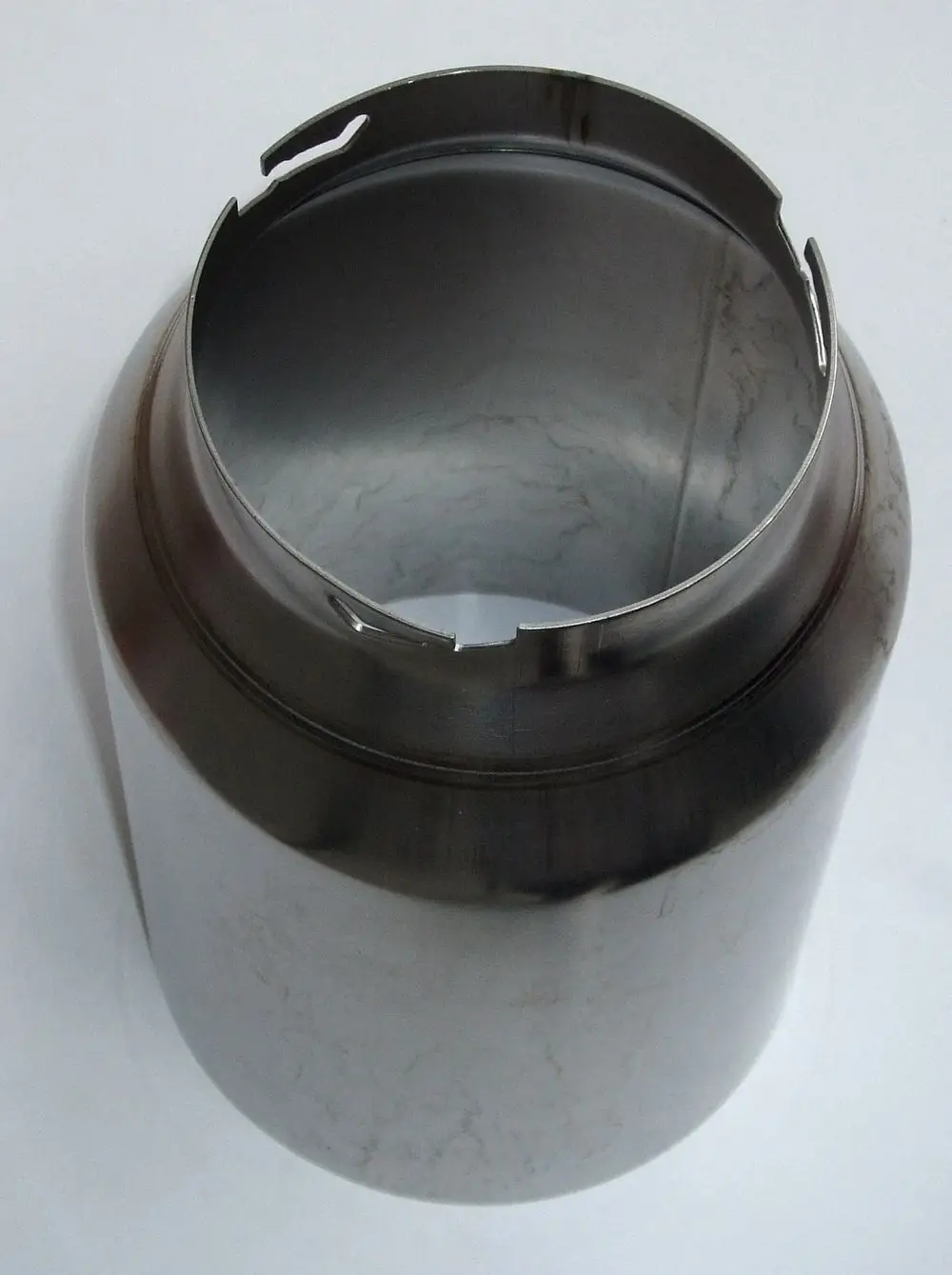 Metallisches Rohr mit glatter Innenfläche und Rillenstruktur am oberen Rand, möglicherweise Teil einer Heizungsanlage von Daikin.